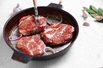 Marbled beef steak on pan and spices on color wooden background