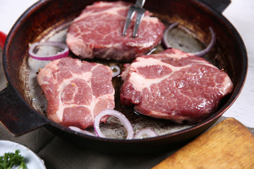 Marbled beef steak on pan and spices on color wooden background