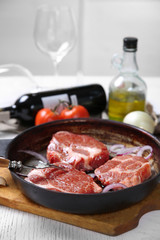 Marbled beef steak and wine bottle on wooden background