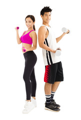 Young happy couple exercising with dumbbell