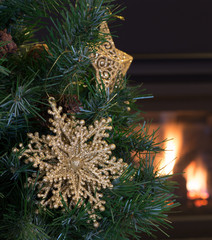 Gold Christmas Star on a Tree With Fireplace in Background