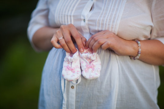 Small pink booties in the hands of mom