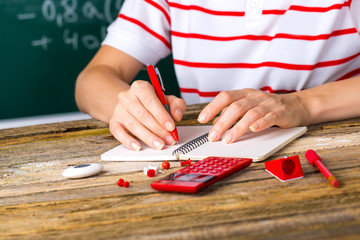 Desk with school supplies. Action hands during a lesson