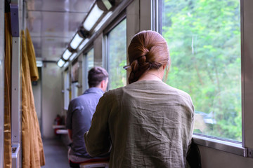 Woman traveller sitting by the train window and reding a book.