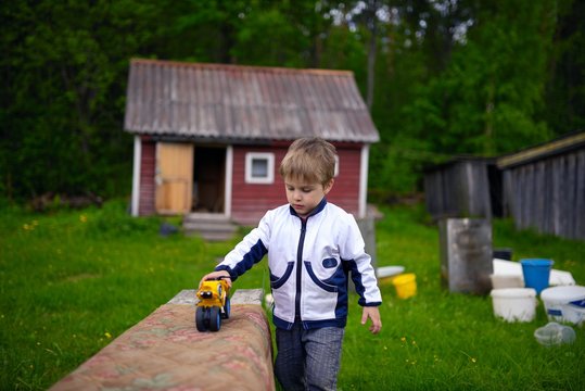 Little boy playing in toy bike in typical Russian village