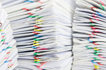 Close up colorful paper clip with pile of report