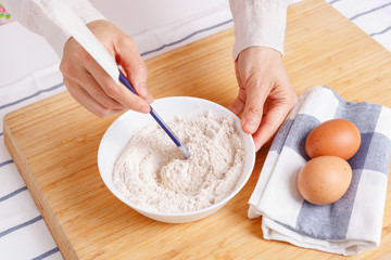 Woman mixing ground flaxseed and flour for baking