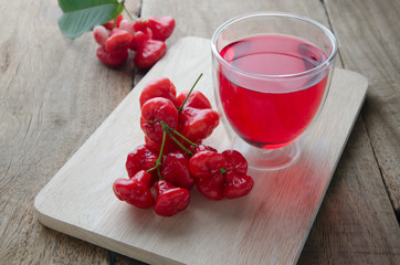 red juice and rose apple on wooden floor.