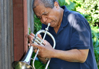 African american jazz musician with his flugelhorn outdoors.