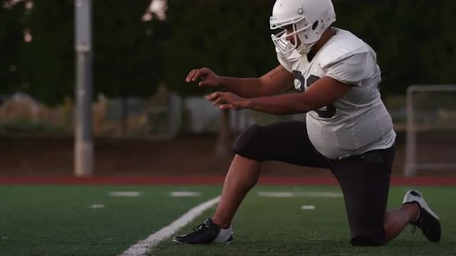 A football player kicking the ball toward the goal posts