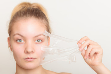 girl removing facial peel off mask