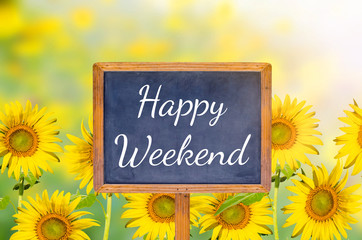 Happy weekend on blackboard with sunflower background