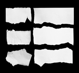 Piece of torn paper on black. Copy space