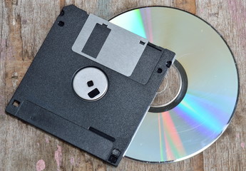 diskette and compact disc on wood board