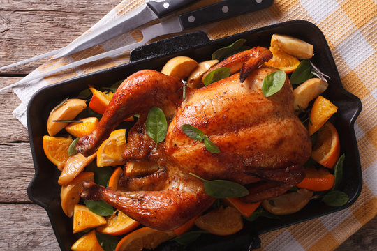roasted chicken with oranges close-up in a pan. Horizontal top view
