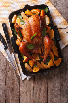 roasted chicken with apples and oranges in a pan. vertical top view
