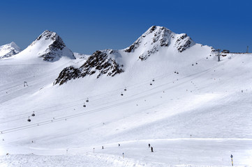 Gondola cable car, ski tow, ski slope and skiers on Tiefenbach glacier in Solden ski resort, Tirol, Austria