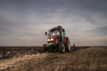 Obraz premium Tractor plowing field