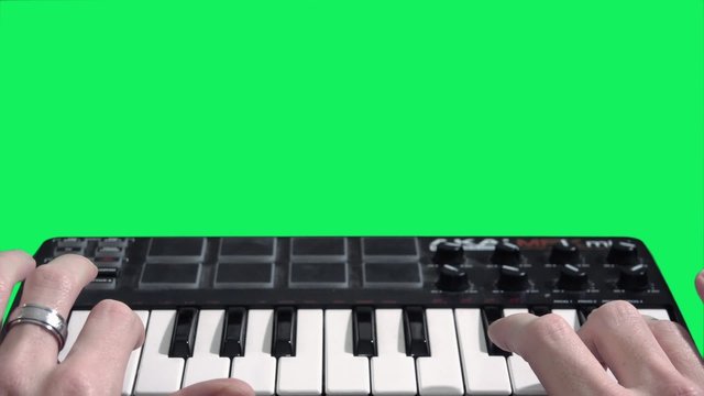 Playing keyboard on green screen - 1080p. Close shot of a hand playing keyboard on a green screen background.