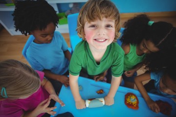 Smiling mixed race kids playing with modelling clay