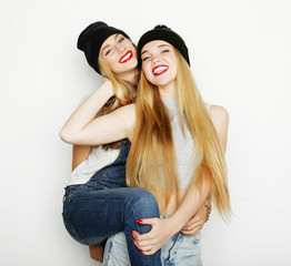 Two young girl friends standing together and having fun.