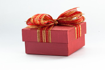 Red gift box with a red ribbon and bow in white isolated backgro