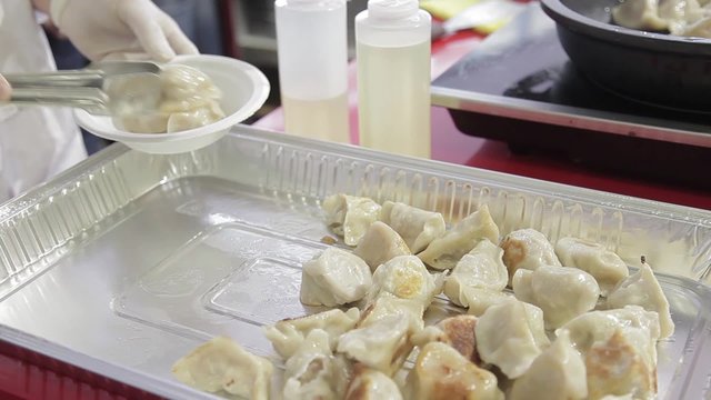 Cocinero preparando Gyoza, empanadillas tailandesas

