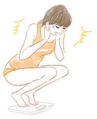 体重計を見てショックを受ける女性