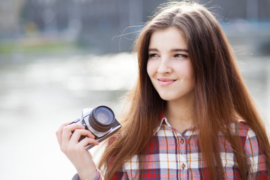 Portrait of a young woman with photo camera
