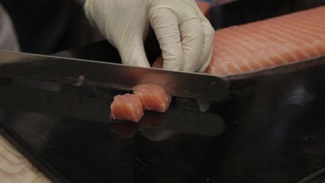 Cocinero cortando salmon en trozos