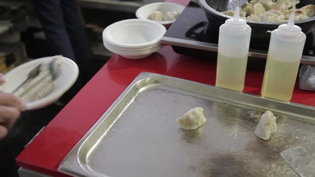Cocinero preparando Gyoza, empanadillas tailandesas

