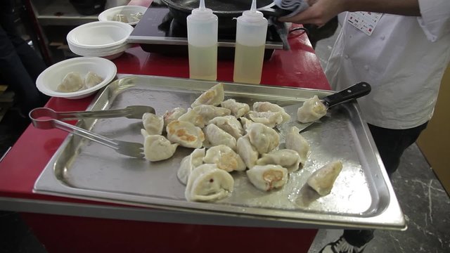 Cocinero preparando Gyoza, empanadillas tailandesas

