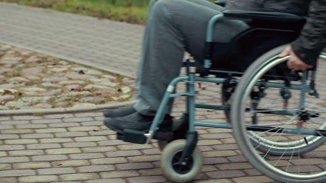 Disabled man using wheelchair on path