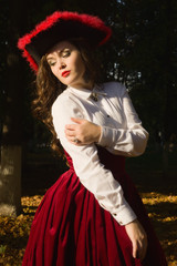 Woman dressed in a retro-style on the autumn alley