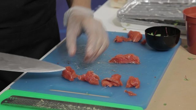 Cocinero cortando salmon en trozos