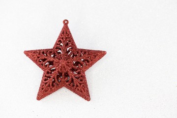 Red christmas star with glittering white background.