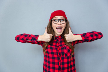 Cheerful hipster woman showing thumbs up