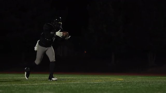 A football player catches a ball and kicks it