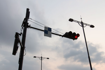 Red traffic light on the street in the evening time