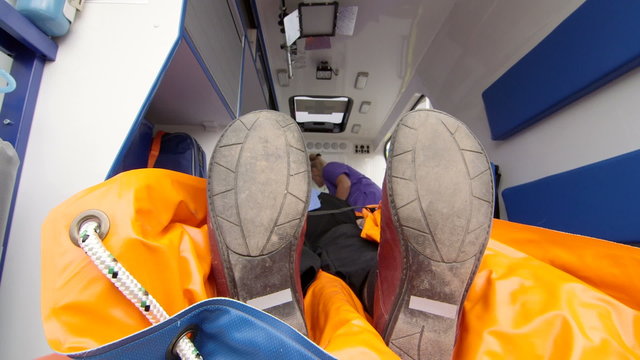 Paramedic provide emergency medical care for senior patient in ambulance