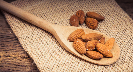 Fine almonds on wooden spoon