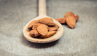 Fine almonds on wooden spoon
