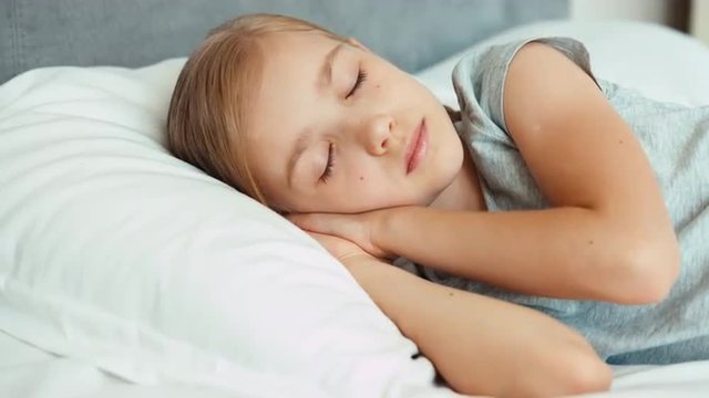 Closeup portrait girl sleeping in a bed and smiling and wakes up