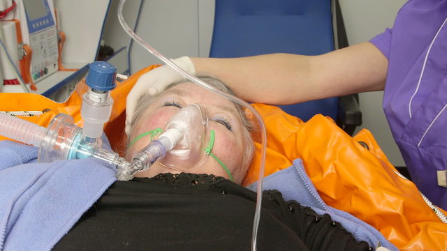 Senior female patient receiving advanced emergency medical care in ambulance closeup