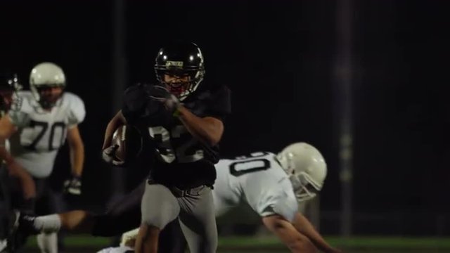 A football player jumps over his opponents to make a touchdown, slow motion