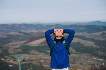 Fototapeta premium Handsome young man standing on a rock, enjoying the view