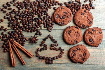 coffee with cinnamon and anise near the biscuit with raisins on wooden background