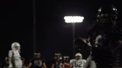 A football player catches a pass, slow motion