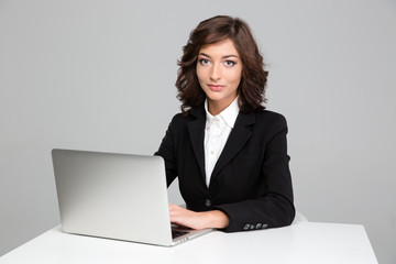 Confident beautiful business woman working using laptop