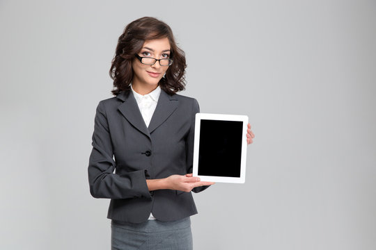 Pretty woman in glasses showing blank tablet computer screen